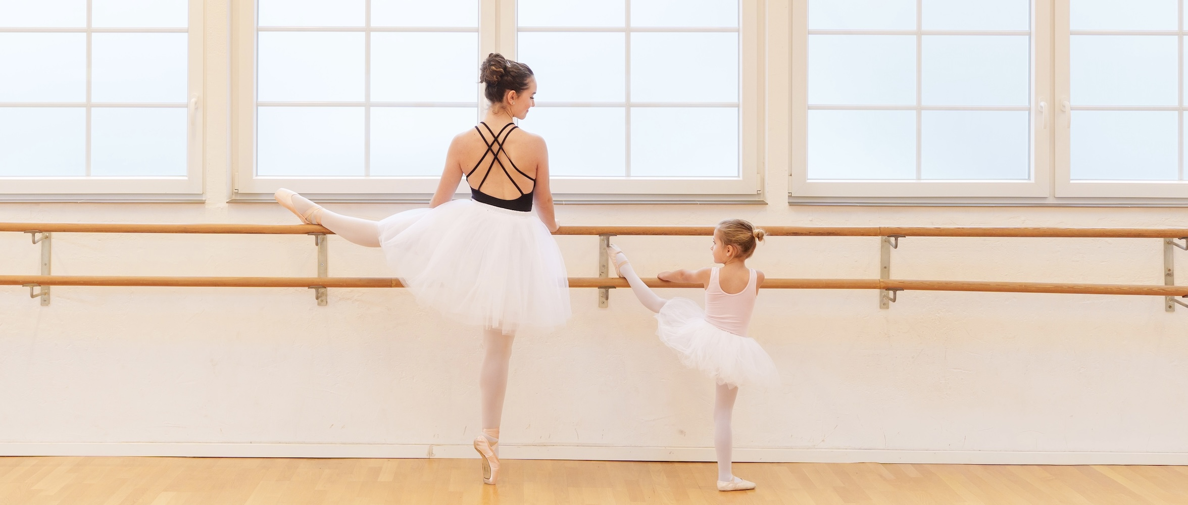     Ballerina auf Spitze mit kleiner Tänzerin an der Ballettstange bei NETT & FRIENDS in Köln