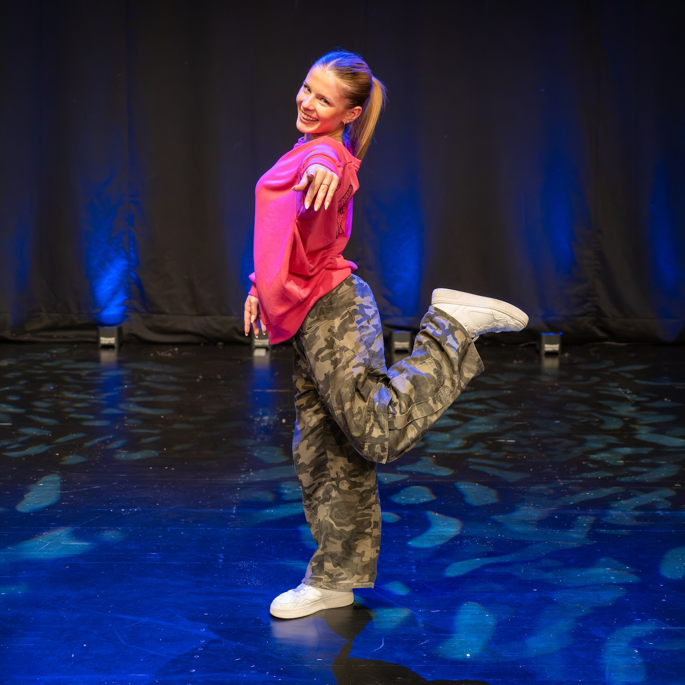 Tänzerin Marie Seither in cooler Hip-Hop-Pose während einer Performance auf der Bühne