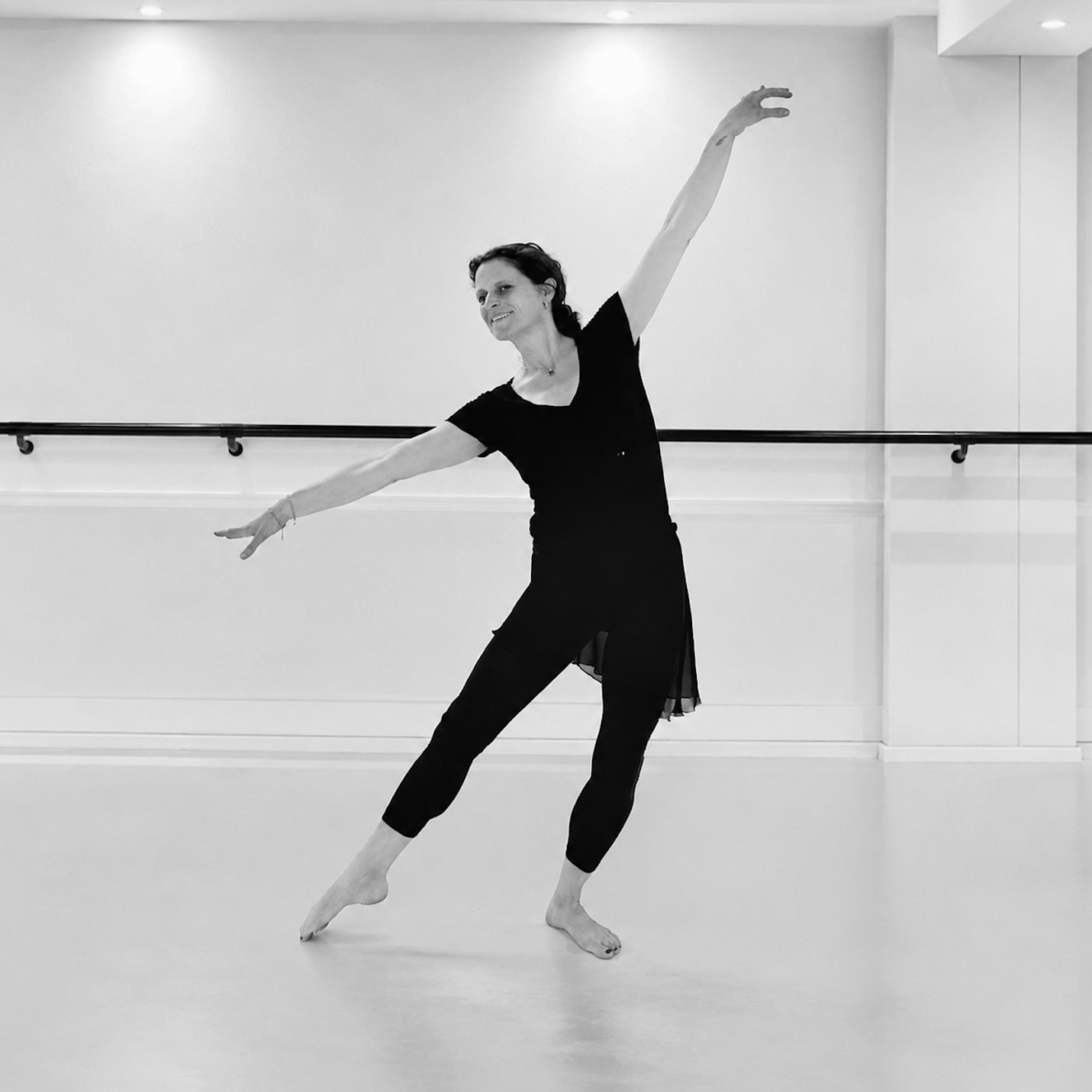     Claudia Franziska Kothen, erfahrene Ballettpädagogin, in einer modernen Tanzpose im professionellen Tanzsaal.