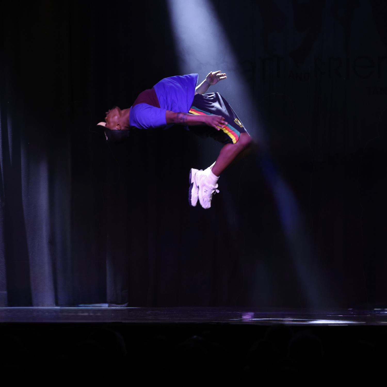 Yann Fandio in actionreicher Breakdance-Pose auf der Bühne